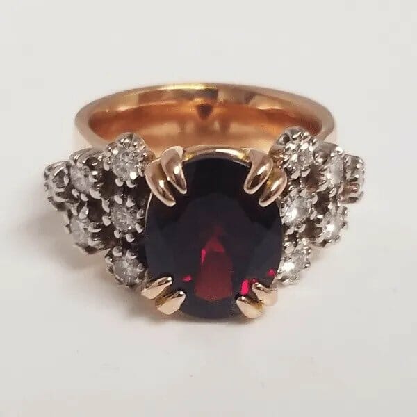 A ring with a garnet stone and diamonds.