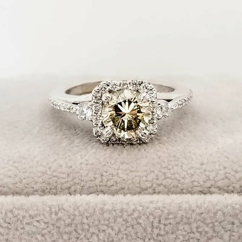 An engagement ring with a brown diamond surrounded by white diamonds.