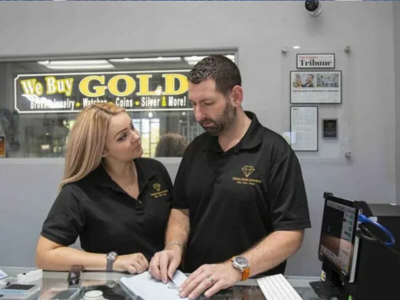 A man and woman looking at a computer screen in a jewelry store.