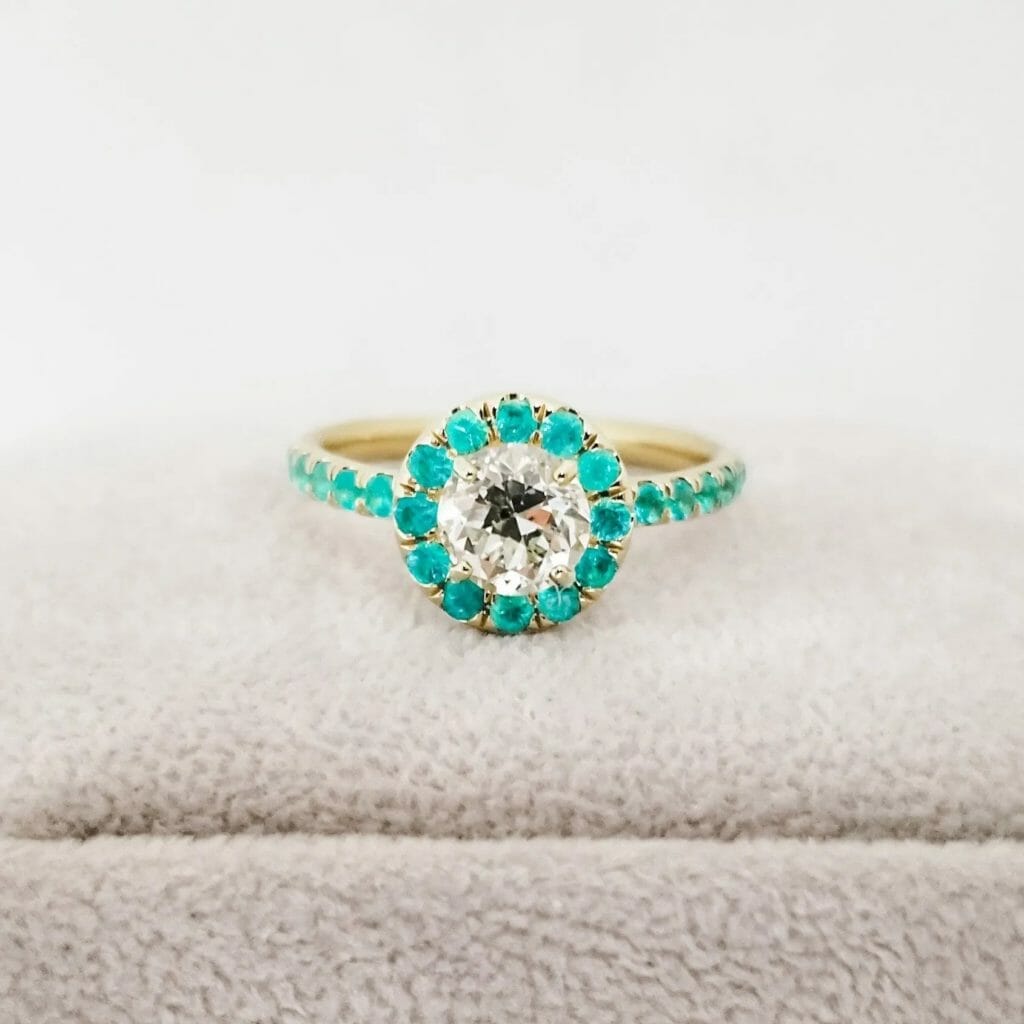 An engagement ring with a turquoise stone and white diamonds.