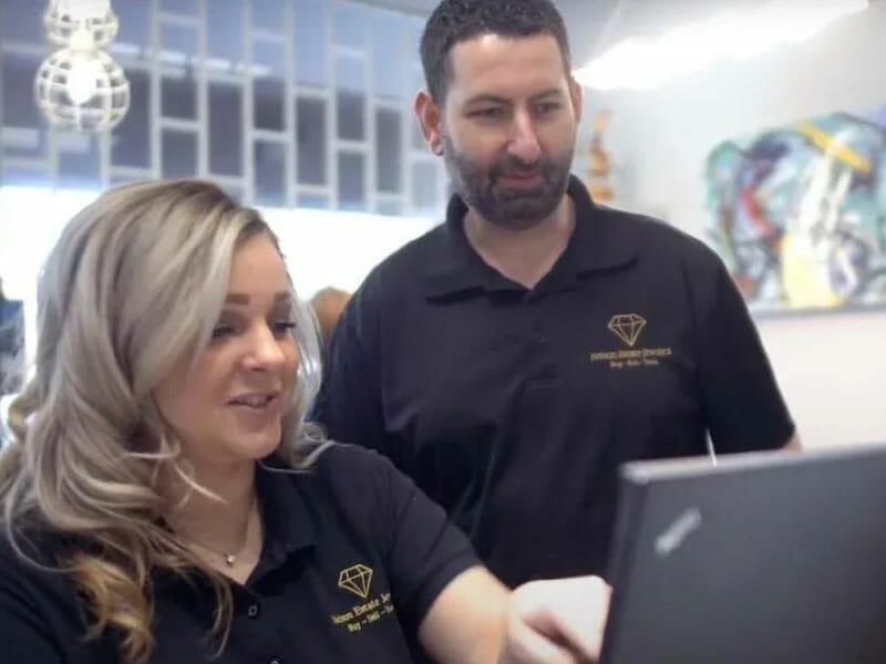 A man and woman looking at a laptop in a salon.