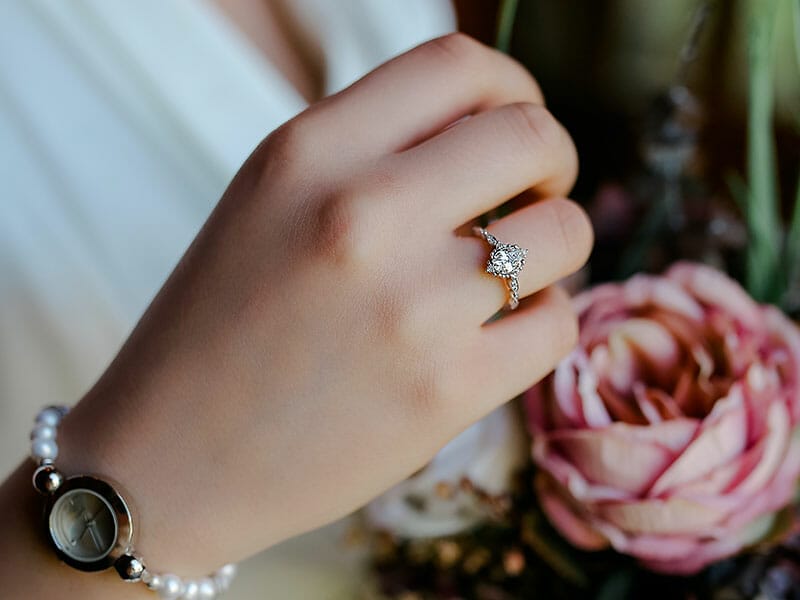 A woman's hand holding an engagement ring.