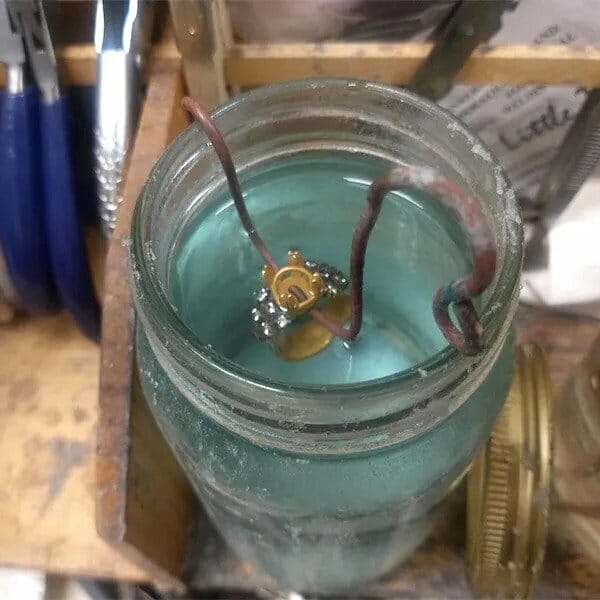 A mason jar filled with water and metal.