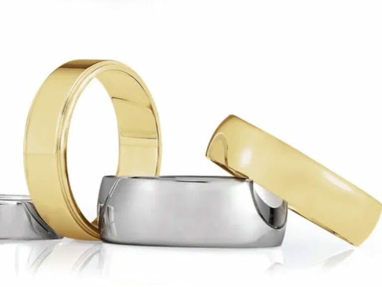 Three gold and silver wedding bands on a white background.