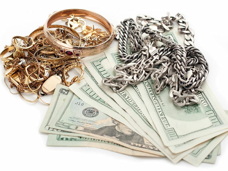 A stack of gold and silver jewelry on a white background.