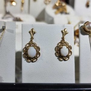 A display of gold and white stone earrings.