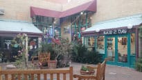 A wooden bench in front of a store at Mill Avenue Shops