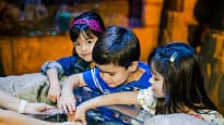 A group of children playing with fish in an aquarium.