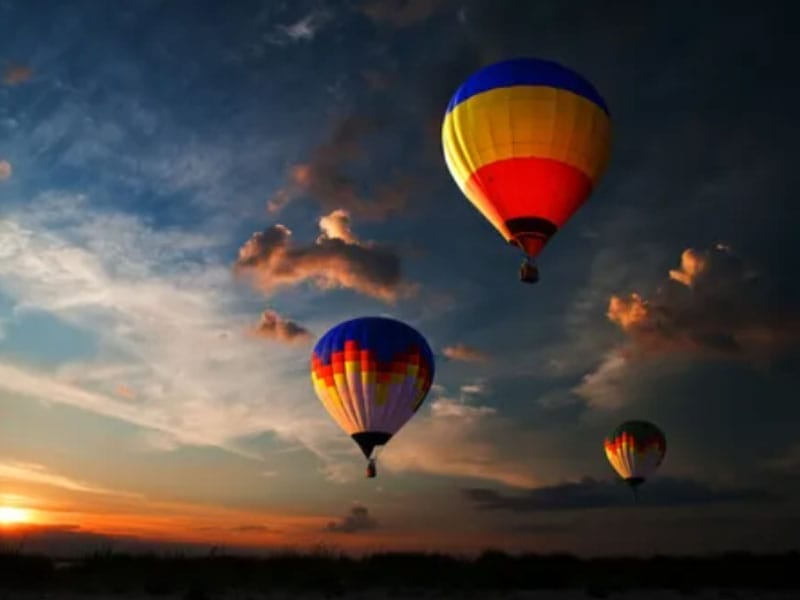 Hot air balloons flying in the sky at sunset