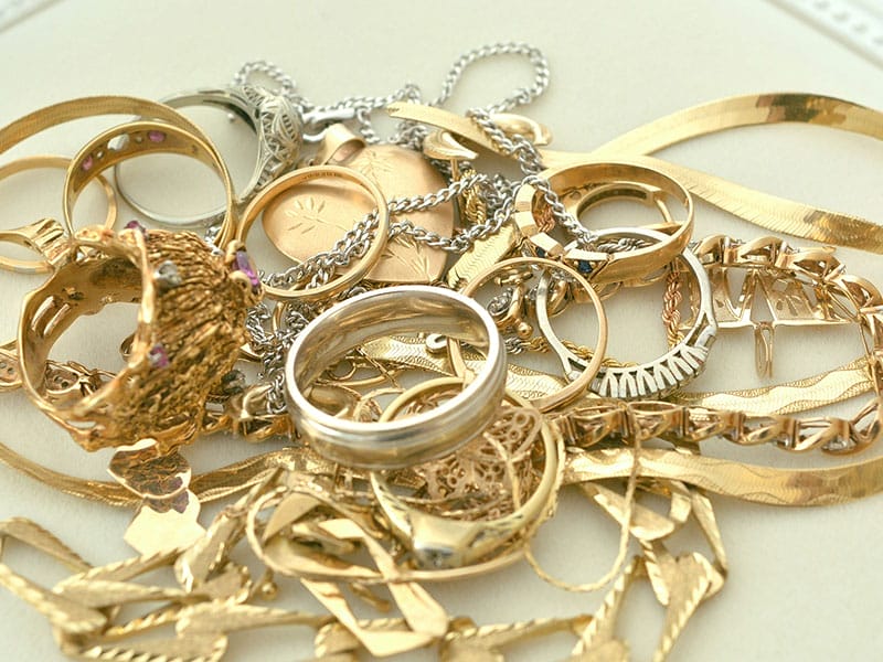 A pile of gold jewelry on a table.