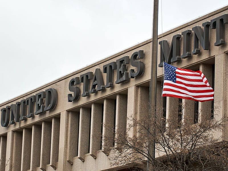 A united states mint building with an american flag.