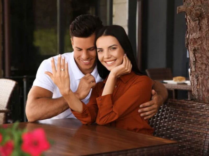 A man and woman posing for a picture at a restaurant.