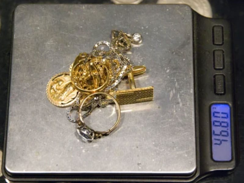 A scale with gold jewelry on top of it.