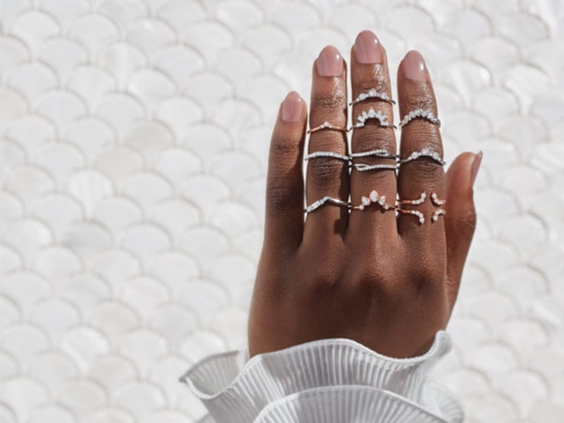 A woman's hand holding a stack of Engagement Ring Wraps.