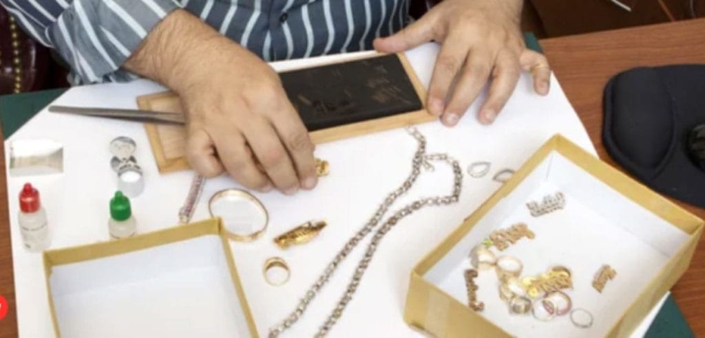 A Jewelry Appraiser is working on a box of jewelry.