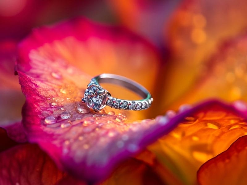 A Promise Ring ring sits on top of a flower.